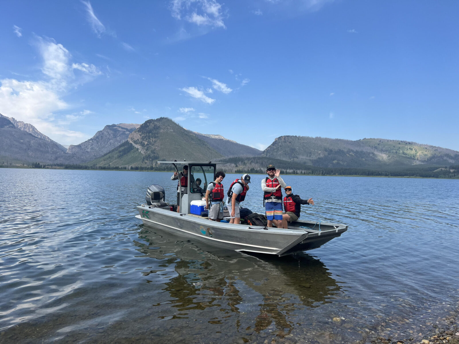 Boat YCP crew members shuttling gear across Jackson Lake for their backcountry hitch.