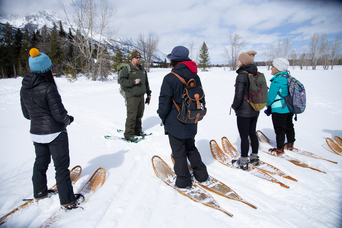 A Ranger takes a group of visitors on an interpretive snowshoe hike. 