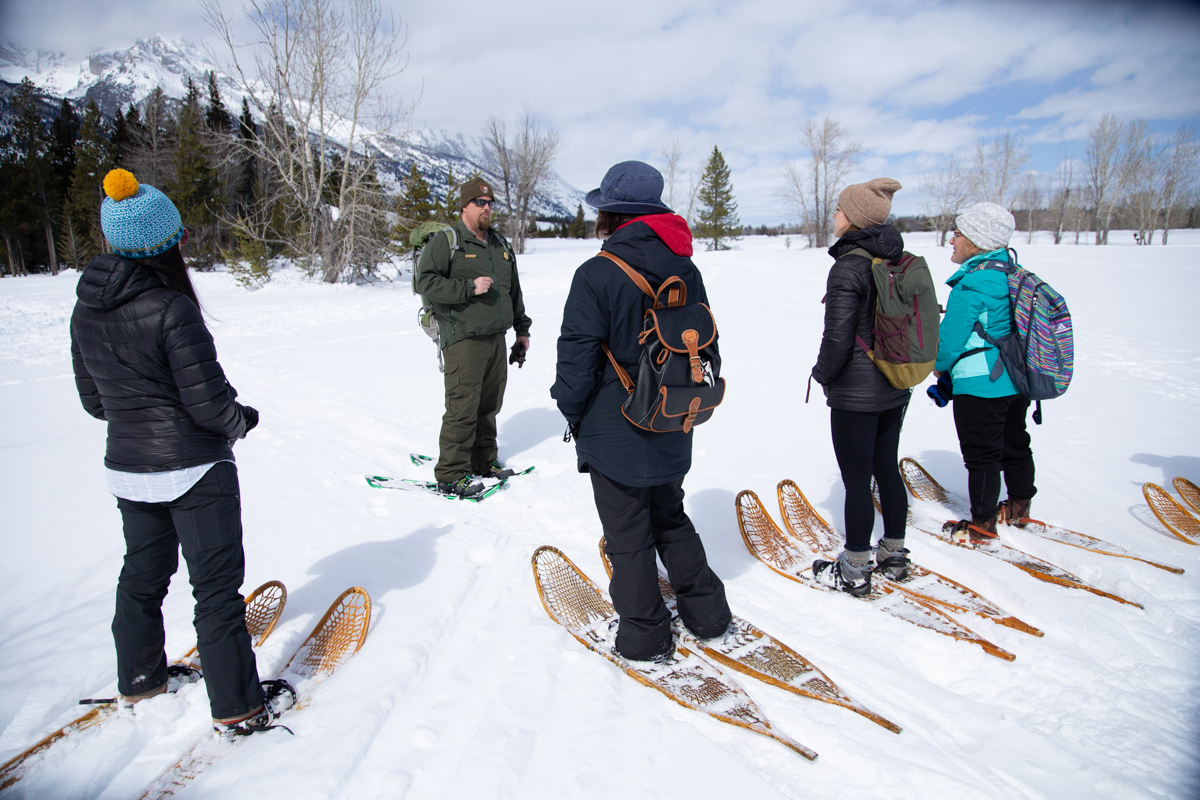 A Ranger takes a group of visitors on an interpretive snowshoe hike.