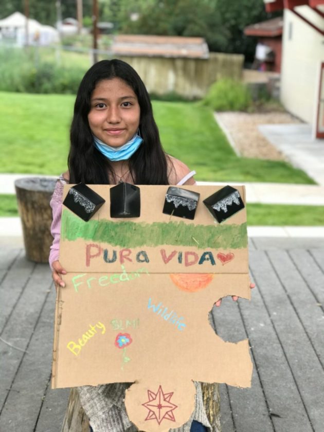 A Pura Vida participant proudly displays her artwork summarizing her experience in the program.