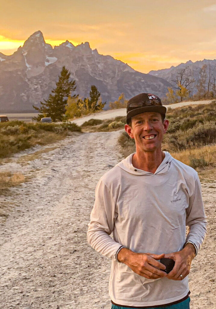 BTAC 4 Travis poses for a portrait with the Teton mountain range in the background.