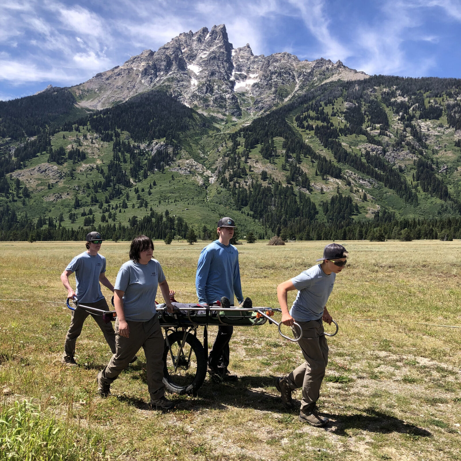 A few crew members try their hand at using a wheeled litter, an essential tool used by the Jenny Lake Rangers for getting injured visitors out of the backcountry.